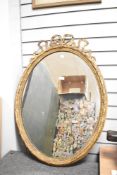 A fine large 19th-century Louis XVI-style oval giltwood mirror, featuring carved foliate, scroll and