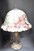 A 20th-century Tiffany-style table lamp, featuring a hand crafted stained glass shade with red and