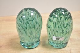 Two Victorian green glass dumps, featuring controlled air bubble inclusions creating an organic