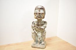 An interesting Indonesian carved wooden figure of a seated, naked emaciated grotesque, modelled