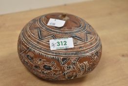 A 20th-century Peruvian Folk Art hand-carved gourd, depicting scenes of daily rural life amongst