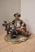A large Capodimonte 'Tramp on Bench' featuring a log burner and crumb fed seagulls, measuring 24.5cm