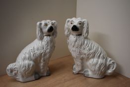 A pair of Staffordshire pottery flatback spaniels, having painted features, cracks to glazing,