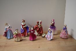 A group of eight Royal Doulton bone china figurines comprising 'Dinky Do' HN 1678, 'Vanity' HN 2475,