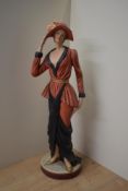A large Art Deco style pottery figurine depicting a female in a long red and black dress wearing a