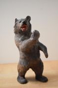 A hand-carved, Black Forest style, wooden bear study depicted in a pugilistic stance, damaged to