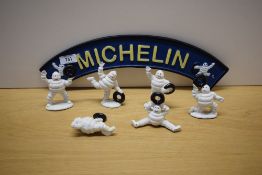 A Michelin painted cast sign with six Michelin men in various poses