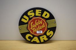 A circular painted cast sign for Safety Tested Used Cars 24cm