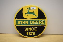 A circular painted cast John Deer since 1876 wall plaque 24cm
