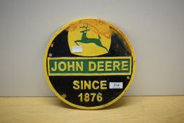 A circular John Deere wall plaque 24cm