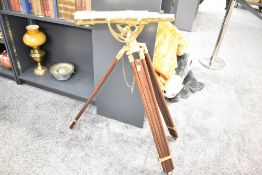 A large late 20th-century nautical-style brass telescope mounted upon a dark hardwood floor