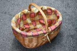A vintage wicker picnic basket, having a handle and colourful fabric liner, 44cm wide and 35cm