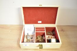 A cream coloured jewellery box, containing a small assortment of costume jewellery, including a