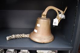 A large 20th-century heavy brass ships bell, featuring a traditional bell shape with wall-mounted