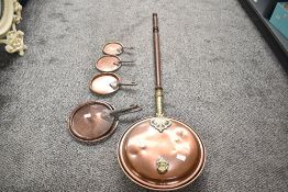 A set of late 19th to early 20th-century copper graduated pans and a copper and brass bed pan having