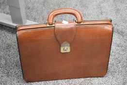 A mid 20th-century British 'SMS' tan leather brief case, featuring a hard-sided frame and metal lock