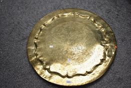A large 20th-century Middle Eastern-style brass charger, having floral and foliate etched detailing,