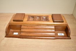A fine 20th-century hand carved oak desk organiser, featuring a central multi-compartment tray,