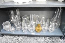 A large selection of late 19th to early 20th-century glass oil lamp chimneys and shades, to