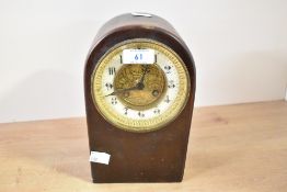 A late 19th to early 20th-century arched top mahogany mantle clock, featuring a floral and foliate