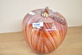 A large decorative contemporary studio art glass apple, featuring a vibrant pulled feather pattern