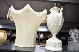 A large 20th-century Neoclassical-style white porcelain urn lamp base, featuring detailed high-