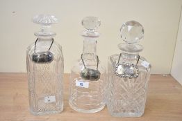 Three early to mid 20th-century crystal cut glass decanters with stoppers, having two silver-