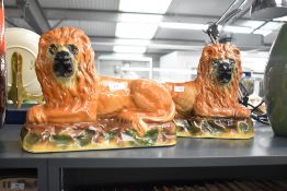 Thought to be 19th-century pair of Staffordshire-style recumbent mantel lions, having amber-coloured