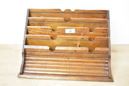 An early to mid 20th-century wooden letter rack, featuring multiple tiered compartments and pen