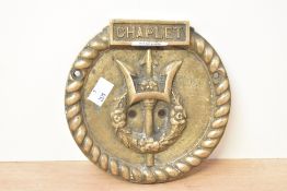 A heavy 20th-century circular brass nautical 'chaplet' wall plaque, featuring a trident and floral