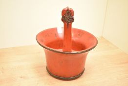 A 20th-century Chinese red lacquered elm wood water bucket, joined together by metal bands,