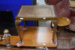 An early 20th Century cane seated dressing table stool on cabriole legs