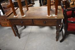 A Victorian oak side table having two frieze drawers, on turned legs, dimensions approx. W129 D69