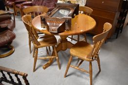 A modern pine kitchen dining table of circular form and a set of four complimentary rubber wood