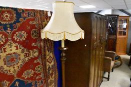 A traditional mahogany standard lamp having fluted column and faux candke fitting, sold with shade