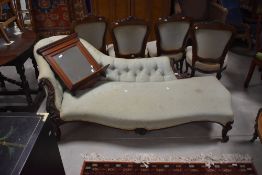 A Victorian mahogany framed chaise longue, having a shaped and deep buttoned back with foliate