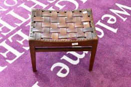 An Arts & Crafts oak stool, having leather strap top, in the manner of Arthur Simpson Handicrafts,