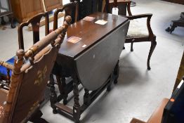 A 20th century oak gate legged table, of traditional form with demi-lune flaps, and gated block