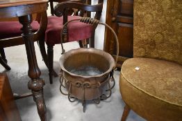 A vintage wrought iron and copper coal bucket in the cauldron style