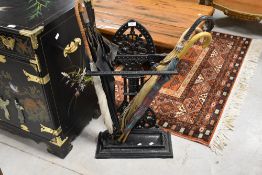 A traditional cast stick stand, in the Coalbrookdale style, over painted , includes a selection of