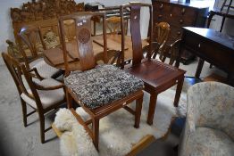 A matched pair of Oriental hardwood dining chairs in the Chinese style having solid seats