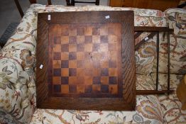 An early 20th Century oak folding game table having square chequerboard top, width approx. 68cm