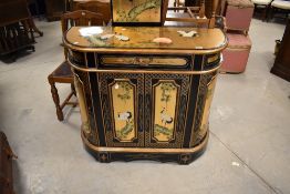 A modern Oriental side cabinet having ebonised and giltwork finish with pictorial crane