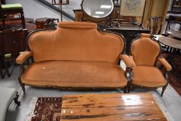 A Victorian inlaid mahogany two piece suite, comprising settee and armchair with carved and inlaid