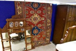 A traditional Kazak style rug , having predominantly red ground, with blue , cream and green