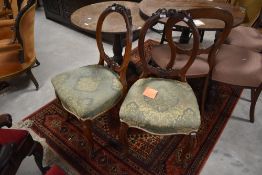A pair of Victorian mahogany balloon back salon chairs having overstuffed seats and shaped legs
