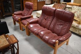 A vintage teak framed russet leather three piece Stressless suite comprising two seater recliner