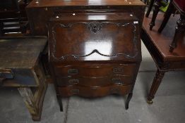 An early 20th Century mahogany bureau having applique decoration to drop flap and serpentine fronted