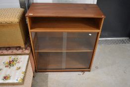 A vintage teak low bookshelf with alcove over sliding glass door section, dimensions approx. W84 D39