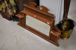 An early 20th pine and mahogany over mantel mirror, with shaped surmount, shelves and bevelled plate